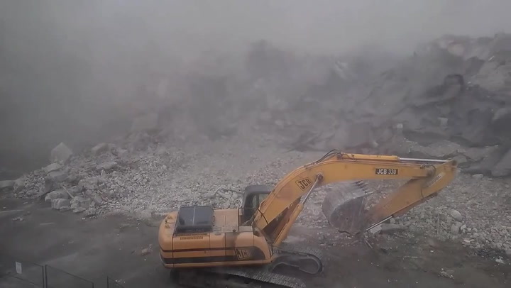 Další šílená ruská demolice. Na bagristu se zhroutil obří panelák, málem to nepřežil